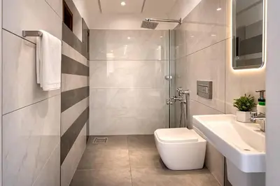 a bathroom with a toilet and a sink and a shower at Grandstaykannur in Kannur