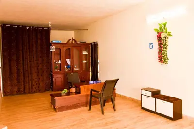 a living room with a chair and a desk at Phoenix View Stay Ooty in Ooty