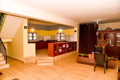 a living room with yellow walls and wooden floors at Phoenix View Stay Ooty in Ooty