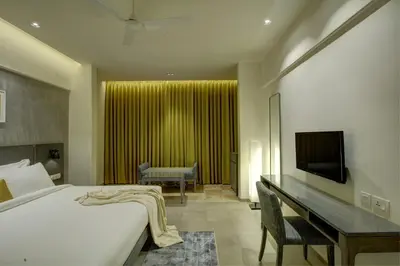 a bedroom with a bed and a desk and a television at Sopanam Heritage in Guruvāyūr