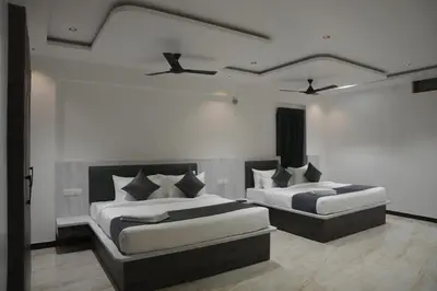 two beds in a room with two at Goldeye's Inn in Erode