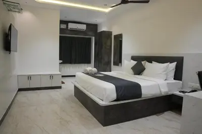 a bedroom with a large bed and a television at Goldeye's Inn in Erode
