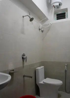 a bathroom with a toilet and a sink at Zen Vista in Vālpārai
