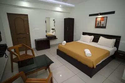 a bedroom with a large bed and a bathroom at AKAN HOTEL AND RESIDENCE in Wayanad