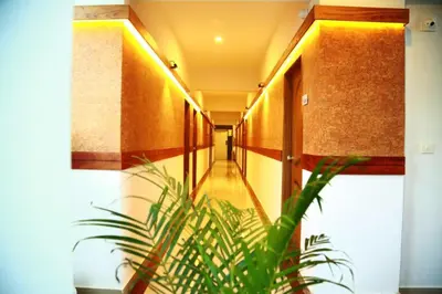 a hallway with a plant in the middle of a building at AKAN HOTEL AND RESIDENCE in Wayanad