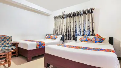 a bedroom with two beds and a chair and curtains at Misty Green Coorg in Madikeri