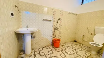 a bathroom with a sink and a toilet at Misty Green Coorg in Madikeri