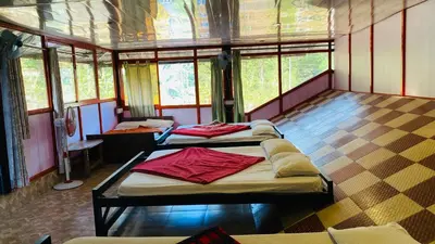 a room with three beds in it with windows at Misty Green Coorg in Madikeri
