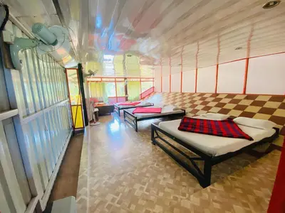 a room with two beds and two tables in it at Misty Green Coorg in Madikeri