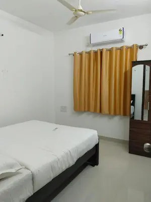 a bedroom with a bed and a brown curtain at ORCHID ELITE BRINDAVAN in Mysore