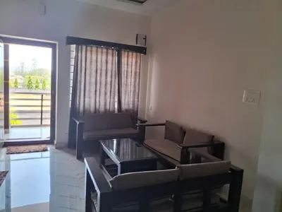 a living room with two chairs and a couch at Royal homes a2 in Kushālnagar