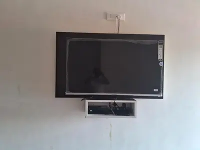 a flat screen tv hanging on a wall at Royal homes a2 in Kushālnagar