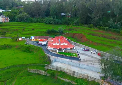 an aerial view of a building in a field at Lauriston Ooty Town Heritage Bungalow by VOYE HOMES in Ooty