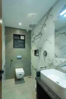 a bathroom with a sink and a toilet and a tub at J Square Inn in Coimbatore