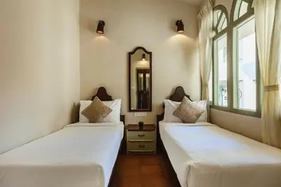 two beds in a room with a mirror at Mango Hill Shola Ooty in Ooty