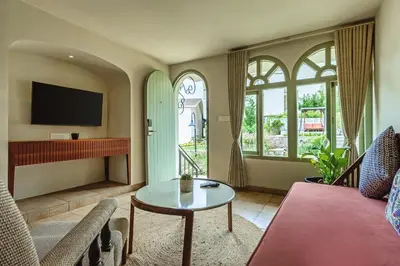 a living room with a couch and a table at Mango Hill Shola Ooty in Ooty