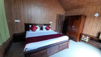 a bedroom with a large bed with red pillows at Ibbanicadu Estate Homestay in Madikeri