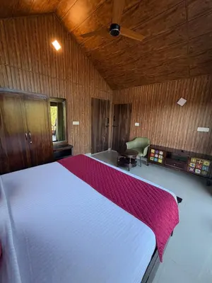 a bedroom with a large white bed in a room at Ibbanicadu Estate Homestay in Madikeri