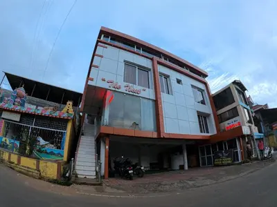 a building on the side of a street with a motorcycle in front at The Travellers Nest in Ooty