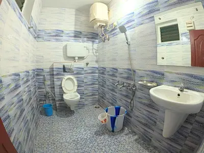 a bathroom with a toilet and a sink at The Travellers Nest in Ooty