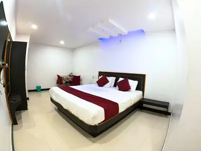 a bedroom with a large bed with red pillows at The Travellers Nest in Ooty