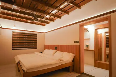 a bedroom with a bed and a window in it at Mangrove Heritage Home, Chendamangalam in Cochin