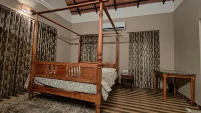 a bedroom with a four poster bed and curtains at Diya's Estate Stay in Thamarassery