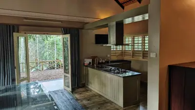 a kitchen with a stove and a counter top at Diya's Estate Stay in Thamarassery