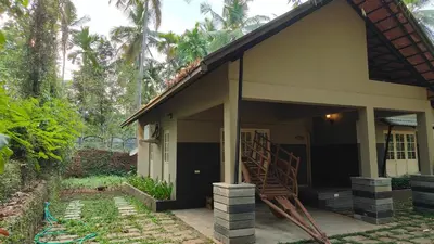 a small house with a staircase in front of it at Diya's Estate Stay in Thamarassery