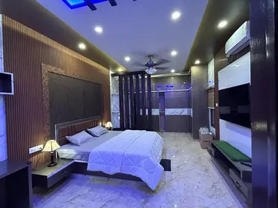 a bedroom with a large bed and a television at Bhoomiputra Mansion in Mysore