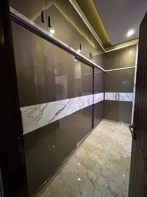 a bathroom with glass walls and a marble floor at Bhoomiputra Mansion in Mysore