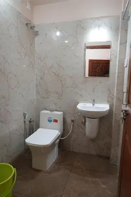 a bathroom with a toilet and a sink at HILL PALACE RESIDENCY COORG in Virajpet