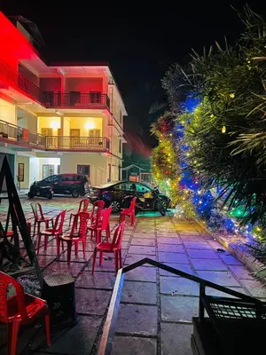 a group of red chairs on a patio at night at Rivera Holiday Home in Vythiri