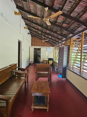 a room with benches and tables in a building at Greene Villa in Palakkad