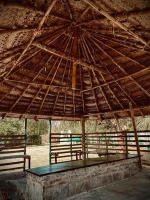 a pavilion with two benches under a large roof at Greene Villa in Palakkad
