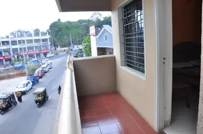 a balcony of a building with a view of a street at Vinayaka Deluxe Lodge in Kushālnagar