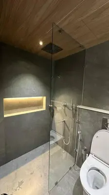 a bathroom with a glass shower with a toilet at The Nova Heights in Kozhikode