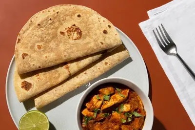 a plate of food with a bowl of curry and a tortilla at Avian Oasis Homestay in Thattakād