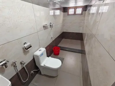 a bathroom with a white toilet and a sink at Avian Oasis Homestay in Thattakād