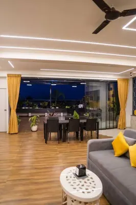 a living room with a couch and a table at Bumblebee - The Penthouse in Mysore