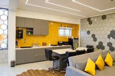 a kitchen with a couch and a table with yellow pillows at Bumblebee - The Penthouse in Mysore