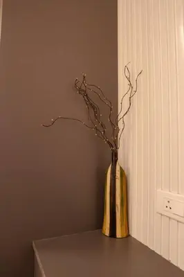 a vase with branches in it sitting on a table at Bumblebee - The Penthouse in Mysore
