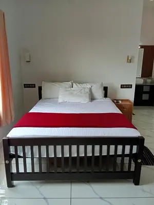 a bedroom with a bed with a red and white blanket at Appu's Nido in Pallipuram
