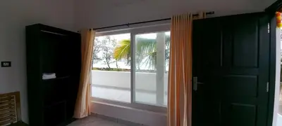 a window in a room with a view of a balcony at Appu's Nido in Pallipuram
