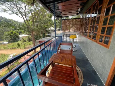 a balcony with benches and a view of the water at Mannath Private Pool Villas at Vellarimala in Wayanad