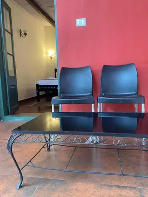 two chairs sitting in front of a red wall at Lakefront Home Hotel in Ooty