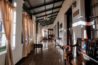 a hallway of a building with wooden floors and windows at Lakefront Home Hotel in Ooty