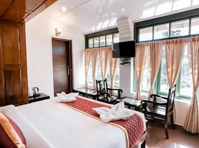 a bedroom with a bed and a tv and windows at Lakefront Home Hotel in Ooty