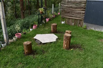 a garden with a stone table in the grass at IInfinity Kodaikanal in Kūkkāl