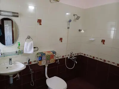 a bathroom with a sink and a toilet and a mirror at Unwind @ Serene Retreat in Palakkad